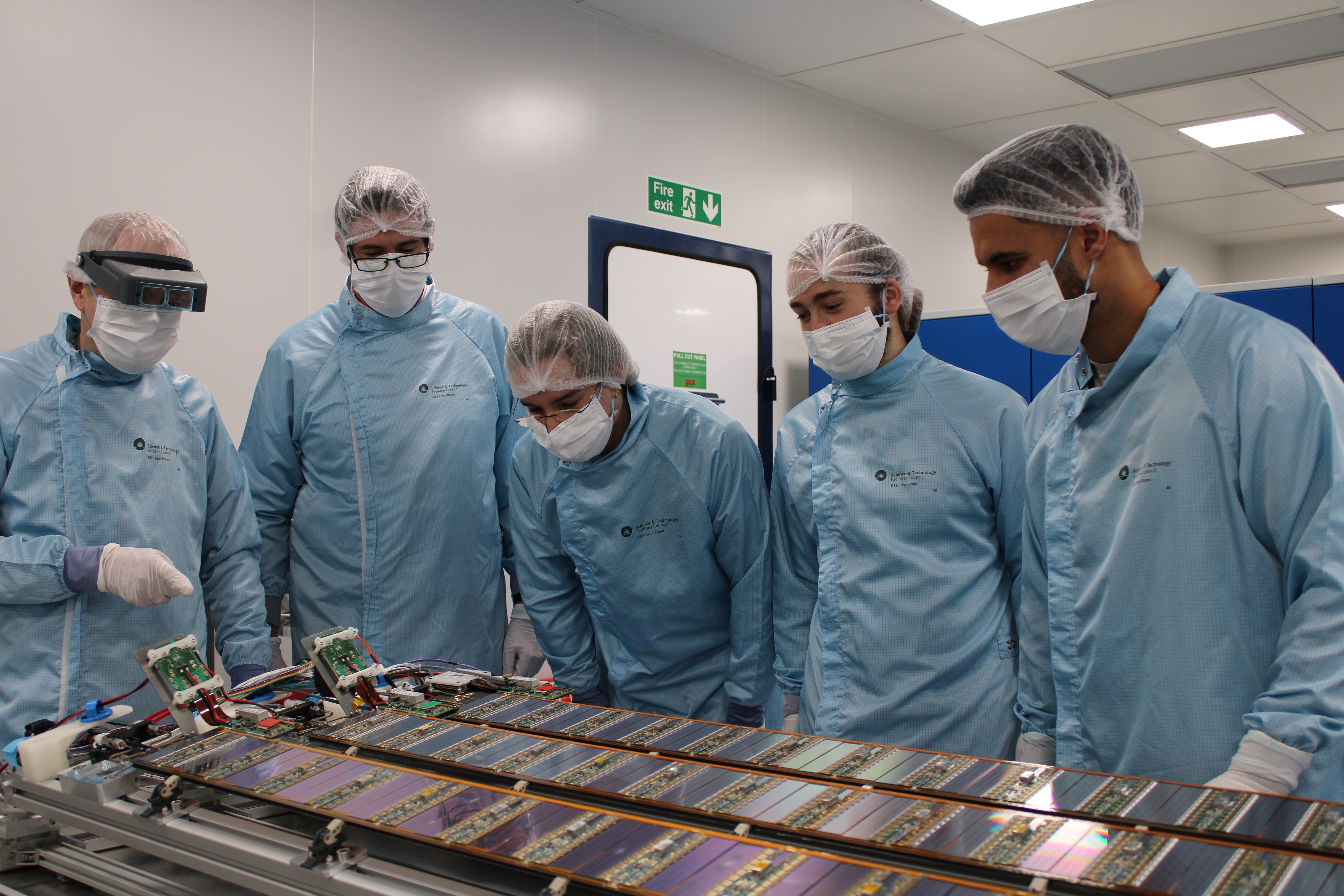 Interconnect staff members inspect three staves developed for the ATLAS experiment
